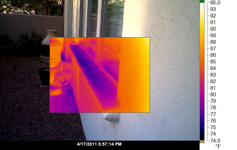 Thermal image showing moisture ingress at window corner on exterior plaster cladding, triangular cool zone indicates leak, building inspection NZ