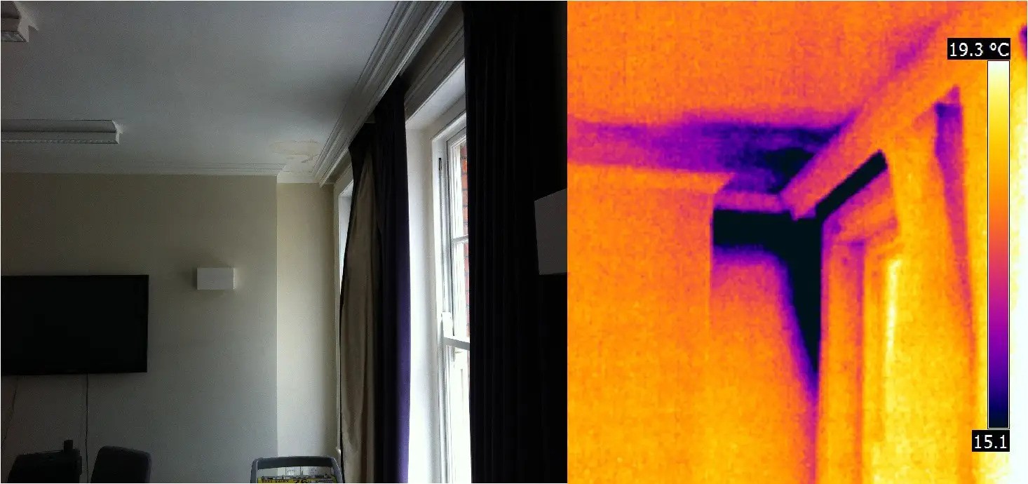 Interior thermal image showing V-shaped cool zone at window head indicating hidden moisture damage, monolithic cladding inspection NZ 
